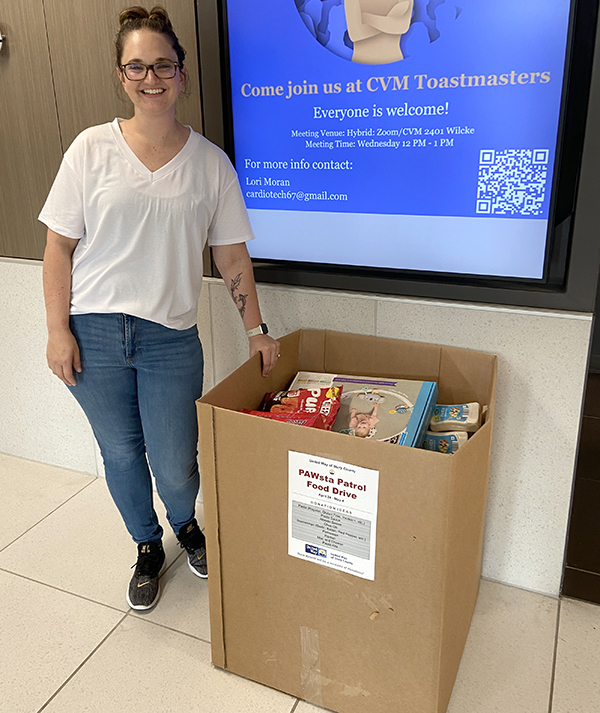 Lisa Lund standing beside food pantry donation box.